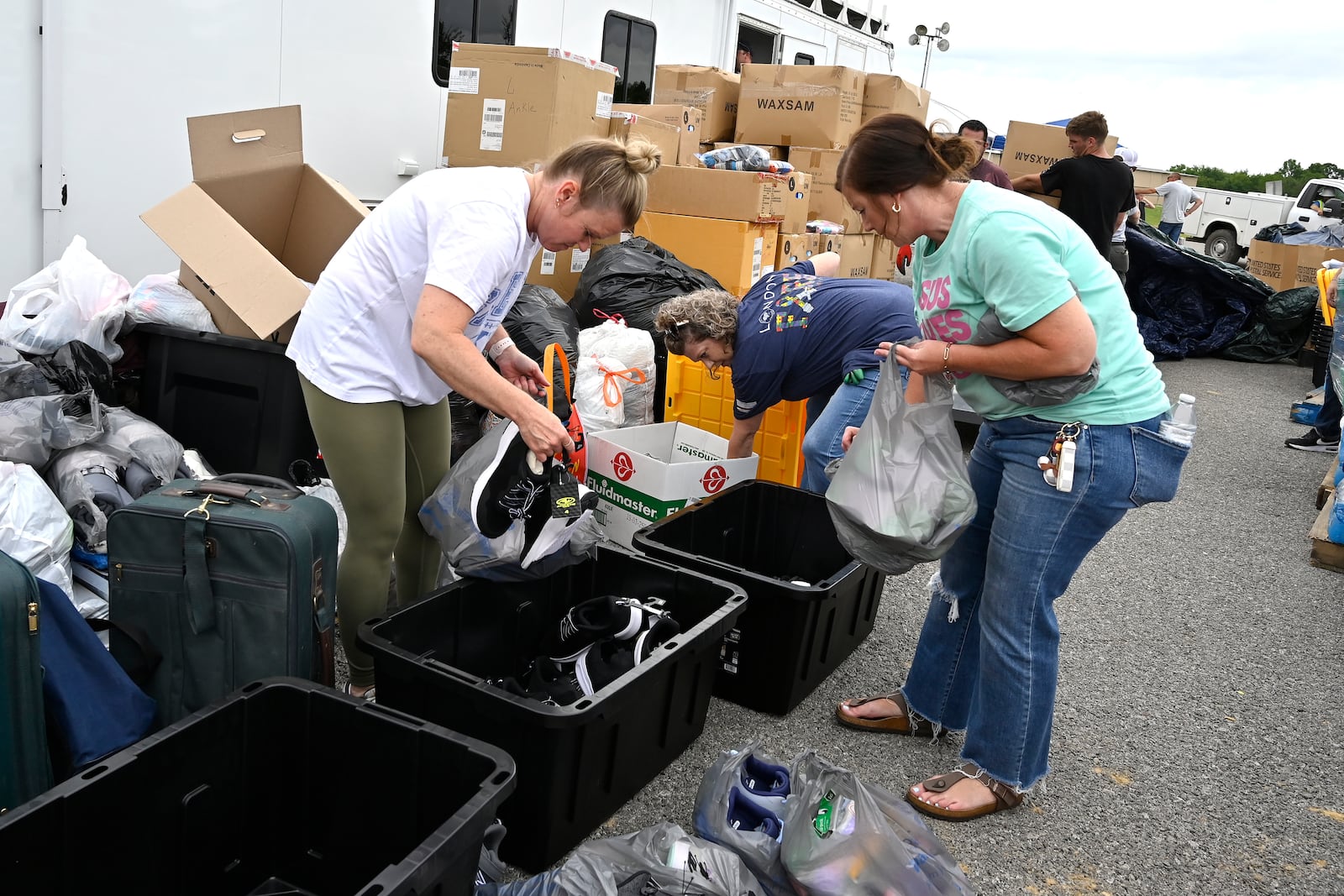 Volunteers sort clothing into bins for distribution at the command center set up at the London-Corbin Airport in London, Ky., Monday, May 19, 2025. (AP Photo/Timothy D. Easley)