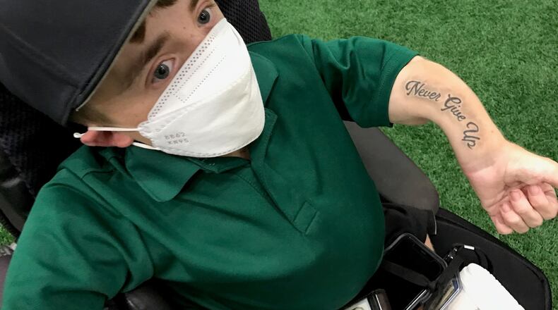 Daniel “Danny” McCarty, the Wilmington College assistant baseball coach who is the Fightin’ Quakers recruiting coordinator and director of baseball operations, shows the “Never Give Up” tattoo he got inked on his left arm this summer. McCarty suffers from an inherited genetic bone disorder -- osteogenesis imperfecta – and has had over 300 broken bones in his 18 years of life. (Photo by Tom Archdeacon)