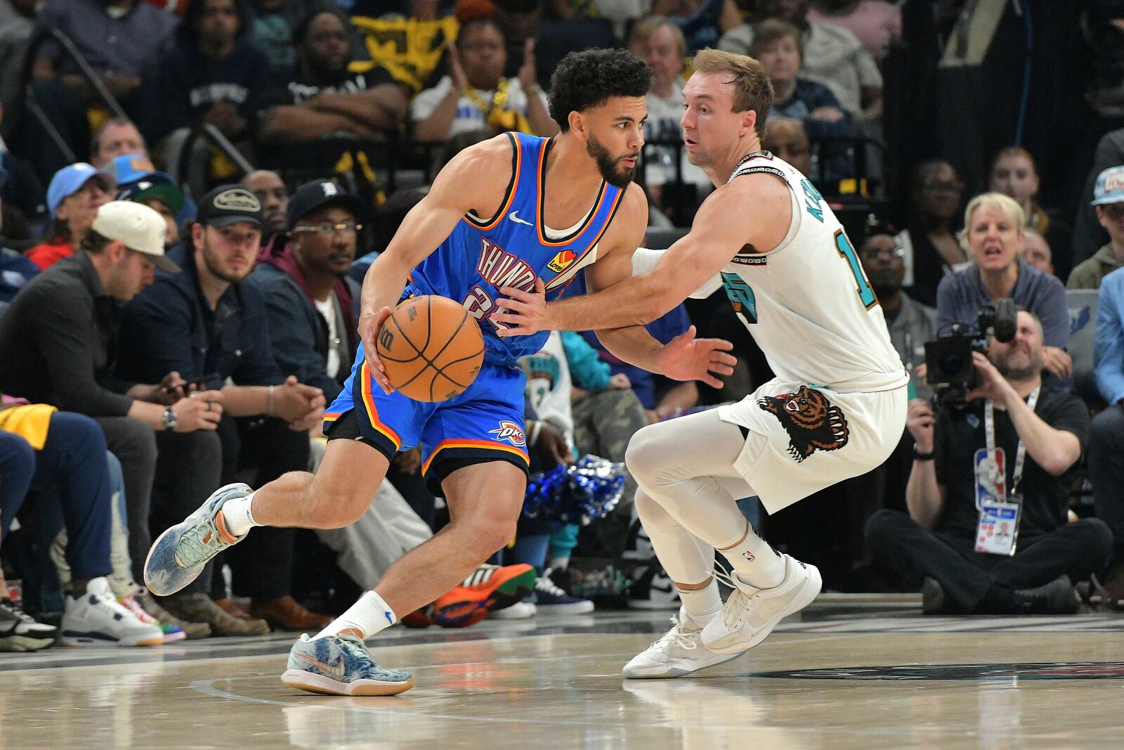 Oklahoma City Thunder guard Ajay Mitchell (25) handles the ball against Memphis Grizzlies guard Luke Kennard, right, in the first half of Game 3 of an NBA first-round playoff series Thursday, April 24, 2025, in Memphis, Tenn. (AP Photo/Brandon Dill)