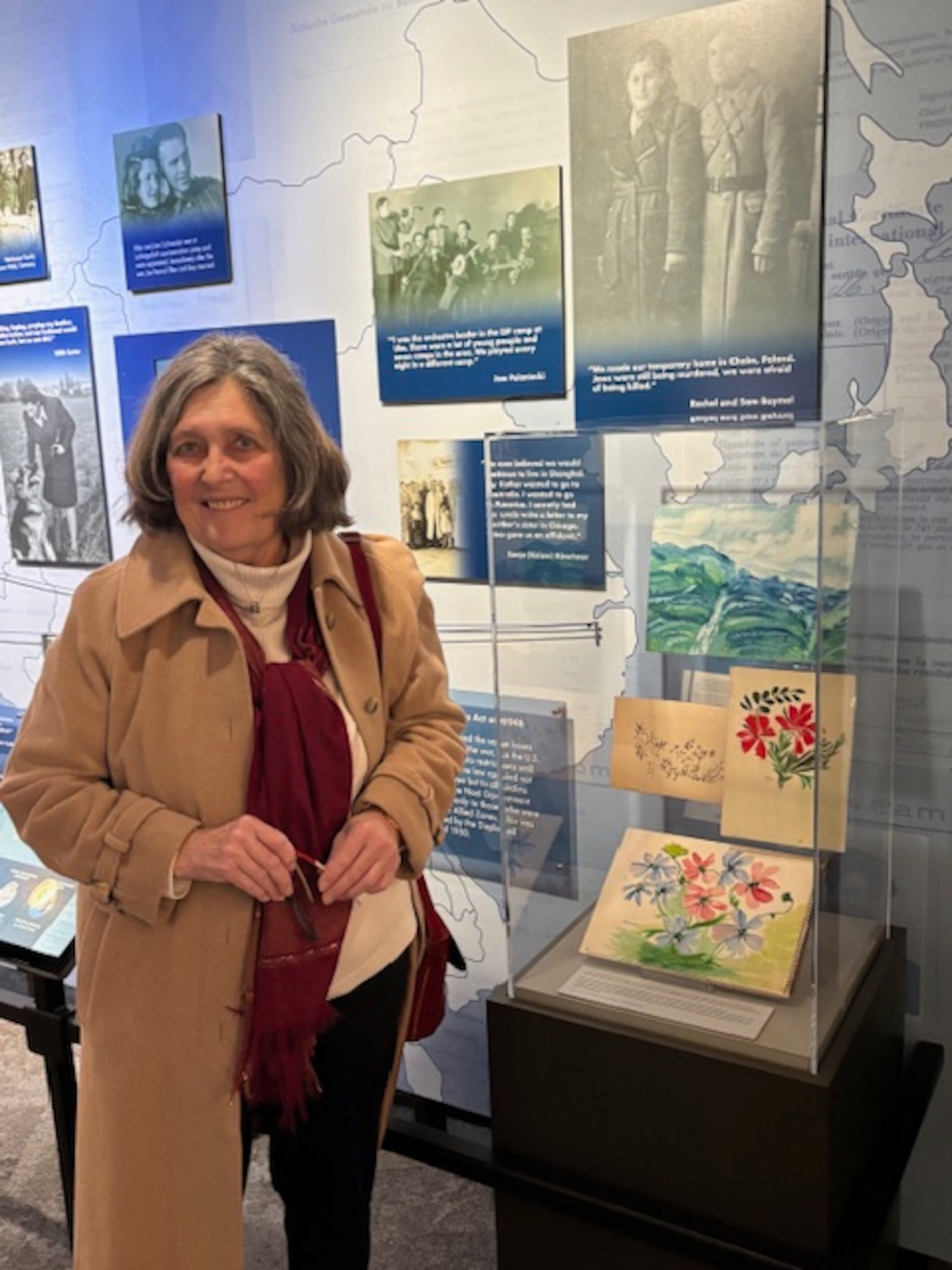 Edna C. Southard, 80, retired curator of collections and exhibitions of the Miami University Art Museum, stands next to one of the display cases that contains her family's artifacts from the Holocaust. The exhibit is at the Holocaust & Humanity Center at the Union Terminal in Cincinnati. CONTRIBUTED