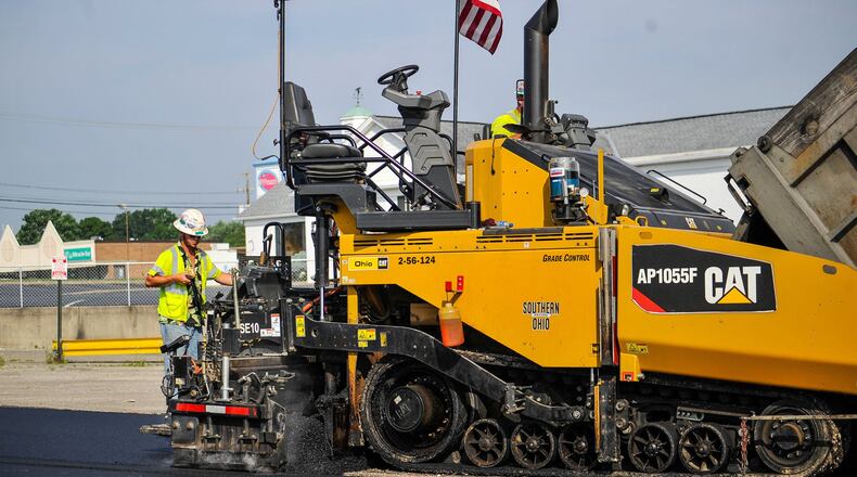 A paving crew recently laid fresh asphalt in parking areas at the former Hamilton West Shopping Center, signaling new things to happen there. NICK GRAHAM/STAFF