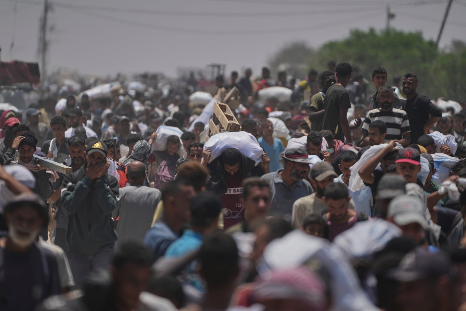 FILE - Palestinians carry bags containing food and humanitarian aid packages delivered by the Gaza Humanitarian Foundation, a U.S.-backed organization, in Rafah, southern Gaza Strip, Monday, June 9, 2025. (AP Photo/Abdel Kareem Hana,File)
