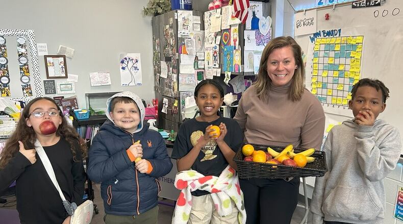 Last summer Middletown Schools Superintendent Deborah Houser traveled to Australia to study schools there. She saw public schools making fresh fruit available to Aussie students throughout the school day and heard from school officials on how it helped keep their students healthier and learn better while in class. Middletown is experimenting with the program with 4th graders at Rosa Parks Elementary. Pictured is teacher Stephanie Brown and some of her students. (Contributed Photo/Journal-News)
