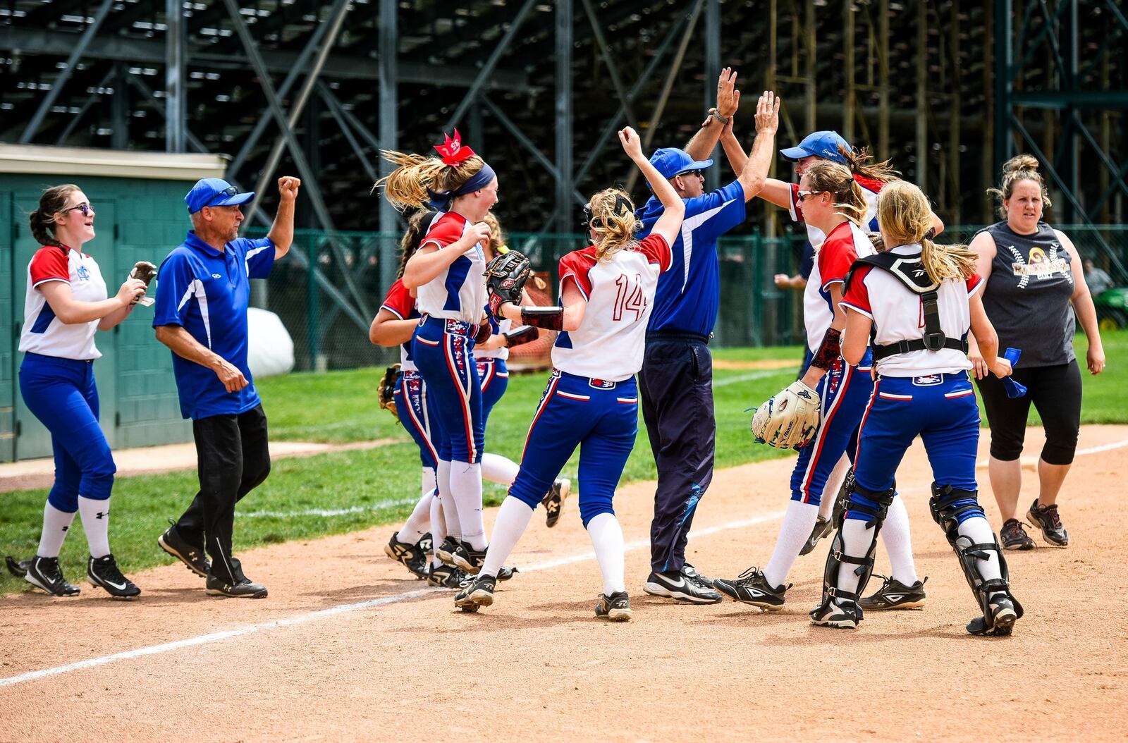 Clinton-Massie’s softball team celebrates its first Division II district championship as Ross coach Anna Winters heads for the dugout Friday at Mason. NICK GRAHAM/STAFF