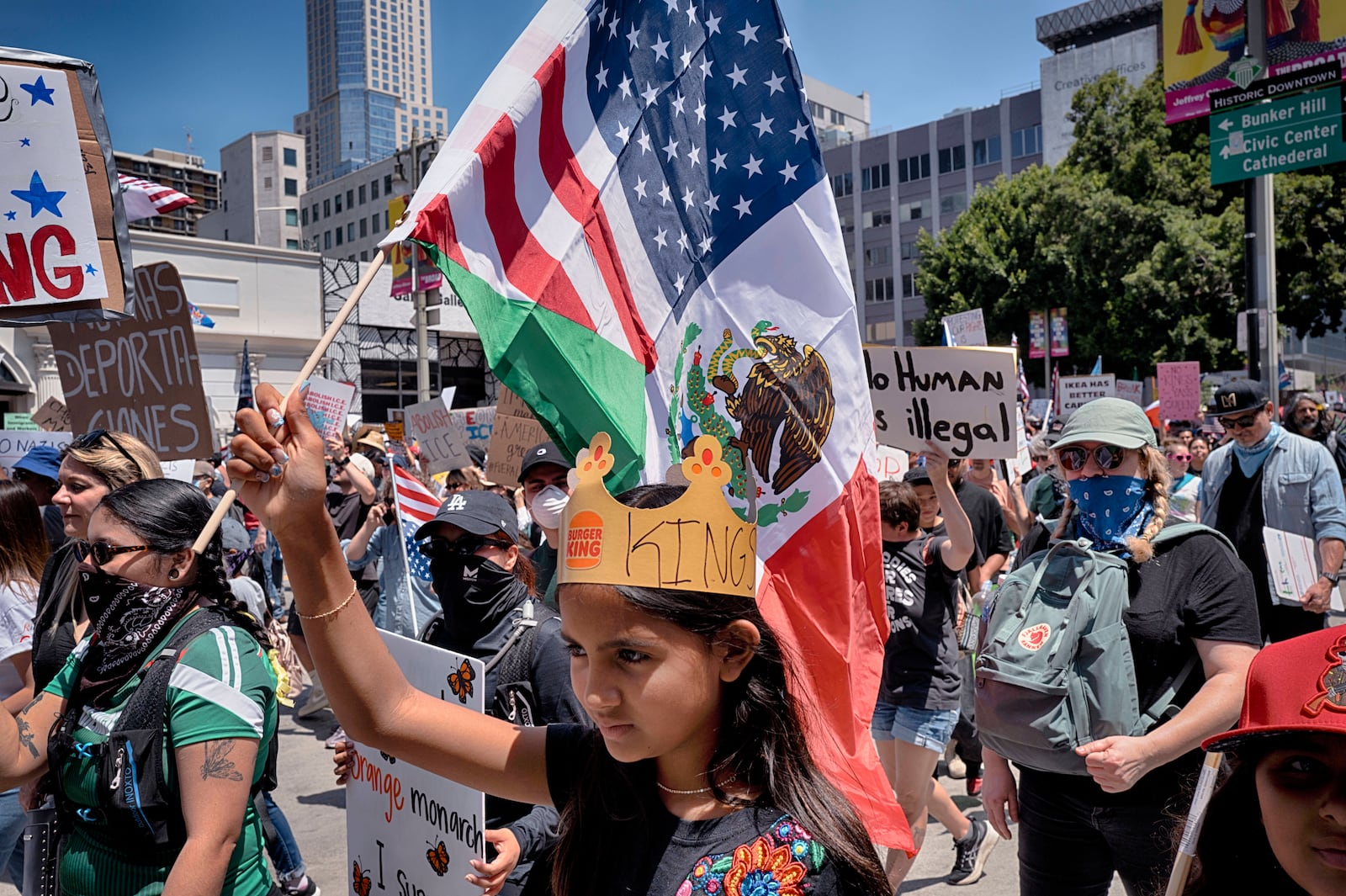 A young protester carries a combination Mexican and U.S. flag during a "No Kings" protest in downtown Los Angeles on Saturday, June 14, 2025. (AP Photo/Richard Vogel)