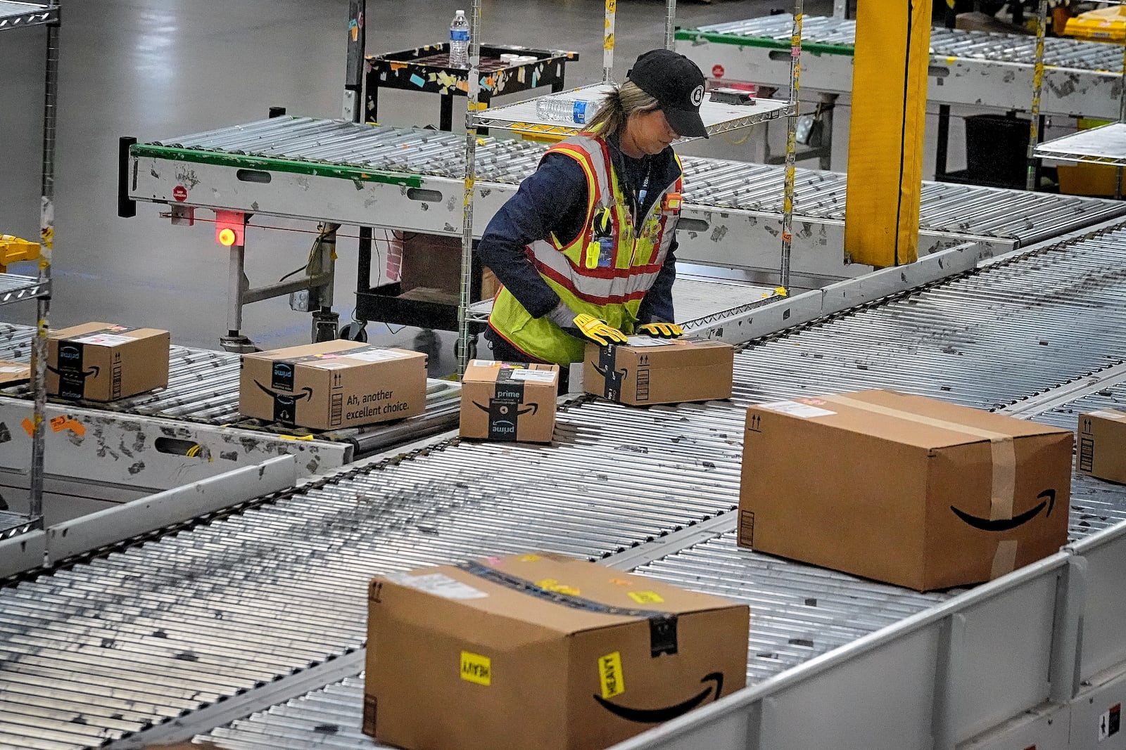 FILE - An Amazon employee puts packages on to a conveyor belt at an Amazon's DAX7 delivery station during Amazon's annual Prime Day event, July 16, 2024, in South Gate, Calif. (AP Photo/Richard Vogel, File)