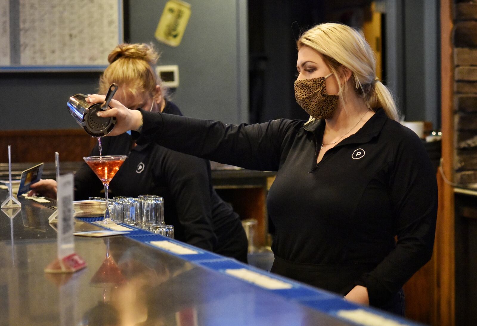 Hayley Moser makes a cosmopolitan for a customer at Putters Sports Grill on Cincinnati Dayton Road Thursday, February 11, 2021 in Liberty Township. NICK GRAHAM / STAFF