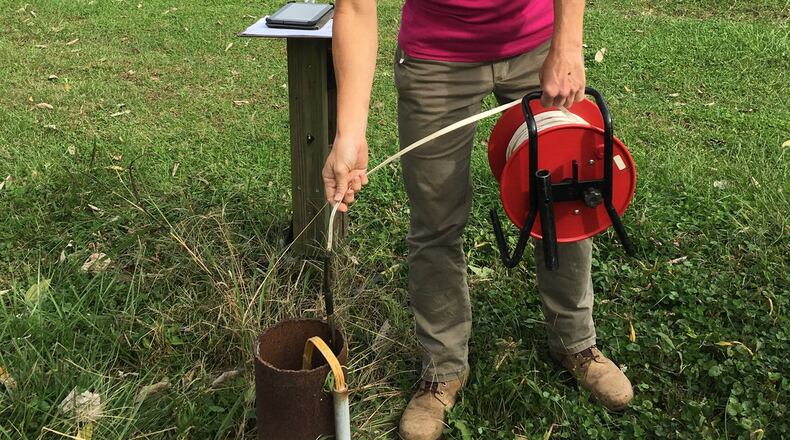 Elli Sigmond, a hydro technician at the Miami Conservancy District, does a groundwater measurement at an observation well in Hamilton County. The well is one of many in the region that the MCD uses to track changes in groundwater storage each month. CONTRIBUTED
