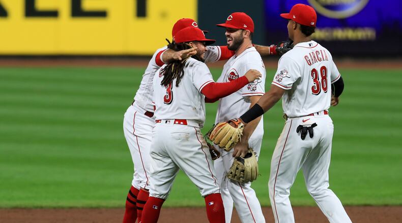 Cincinnati Reds' Joey Votto, back left, Freddy Galvis, second from left, Mike Moustakas, middle, and Jose Garcia celebrate after the Reds defeated the Pittsburgh Pirates 1-0 in a baseball game Wednesday, Sept. 16, 2020, in Cincinnati. (AP Photo/Aaron Doster)