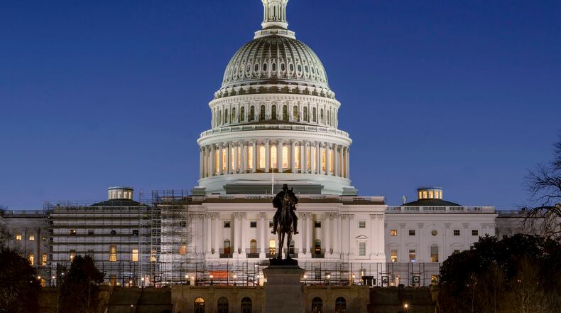 FILE - The U.S. Capitol building is seen before sunrise on Capitol Hill in Washington, Monday, March. 21, 2022. With an urgent funding request stuck in Congress, the Health Resources and Services Administration says it can no longer cover medical bills for COVID tests and treatments for uninsured people and will stop taking claims at midnight Tuesday. (AP Photo/Gemunu Amarasinghe, File)