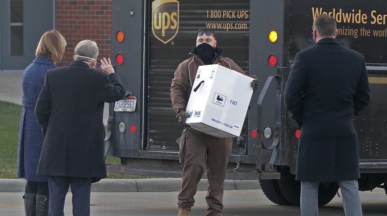 Gov. Mike DeWine and his wife, Fran, along with Springfield Regional Medical Center President Adam Groshans, right, greet a UPS driver as he delivers the first COVID-19 vaccine at the hospital Tuesday, Dec. 15, 2020. BILL LACKEY/STAFF