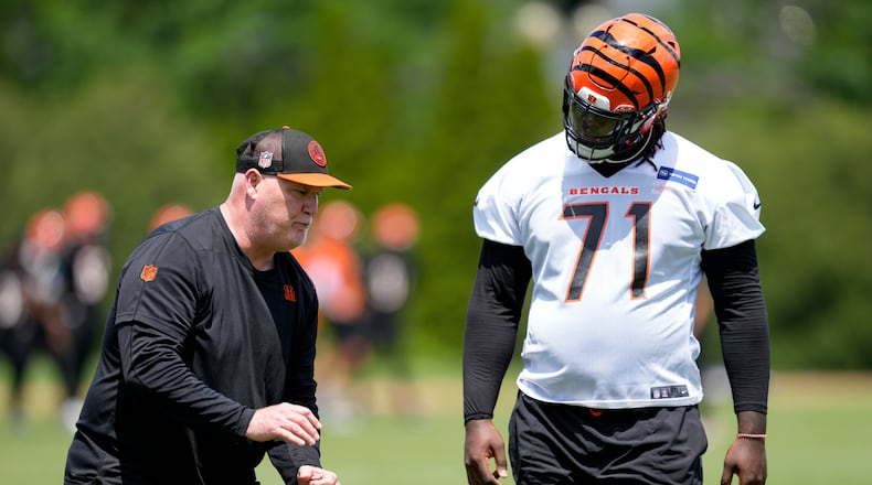 Cincinnati Bengals offensive line coach Frank Pollack, left, speaks with Amarius Mims (71) during a NFL football practice, Tuesday, May 28, 2024, in Cincinnati. (AP Photo/Jeff Dean)