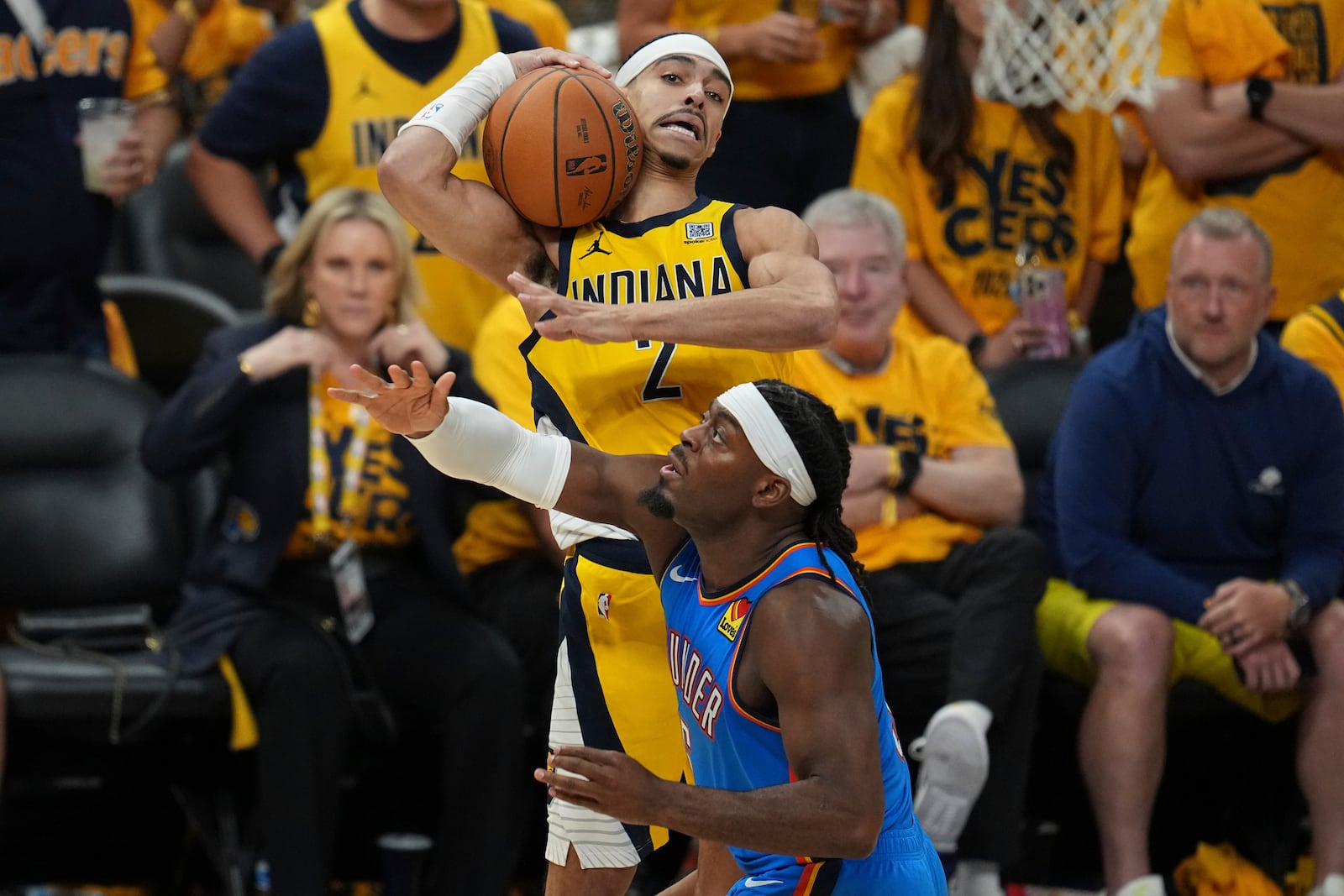 Indiana Pacers guard Andrew Nembhard (2) rebounds over Oklahoma City Thunder guard Luguentz Dort during the second half of Game 6 of the NBA Finals basketball series, Thursday, June 19, 2025, in Indianapolis. (AP Photo/Michael Conroy)