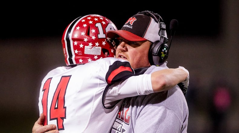 Madison coach Steve Poff hugs Noah Lehman after their 24-16 loss to Wheelersburg in the Division V, Region 20 final on Nov. 17, 2018, at Hilliard Darby High School in Hilliard. NICK GRAHAM/STAFF