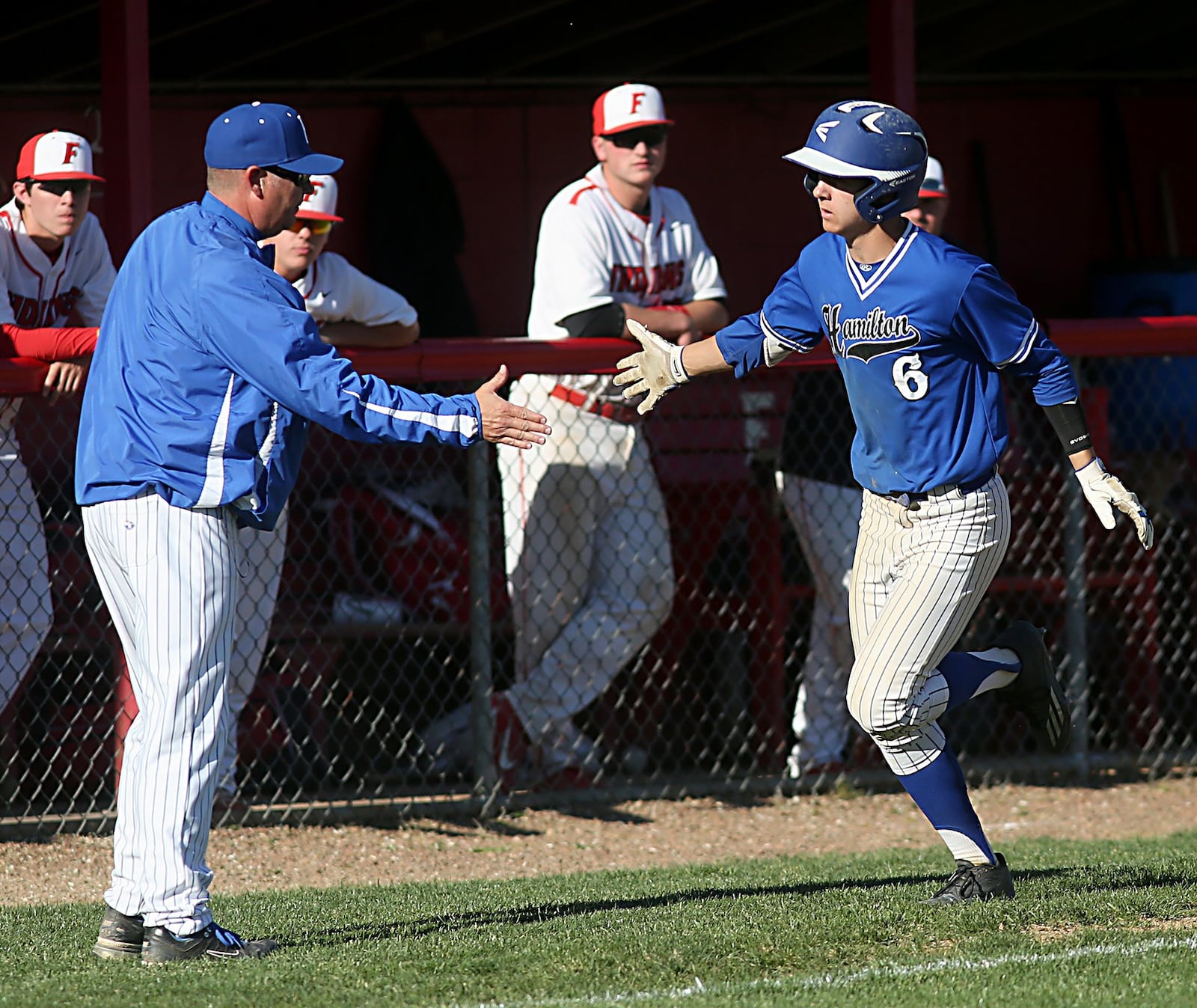 Hamilton’s Payton Pennington is congratulated by coach Joey Lewis after hitting a two-run homer in the fifth inning of Sunday’s game against host Fairfield at Joe Nuxhall Field. CONTRIBUTED PHOTO BY E.L. HUBBARD