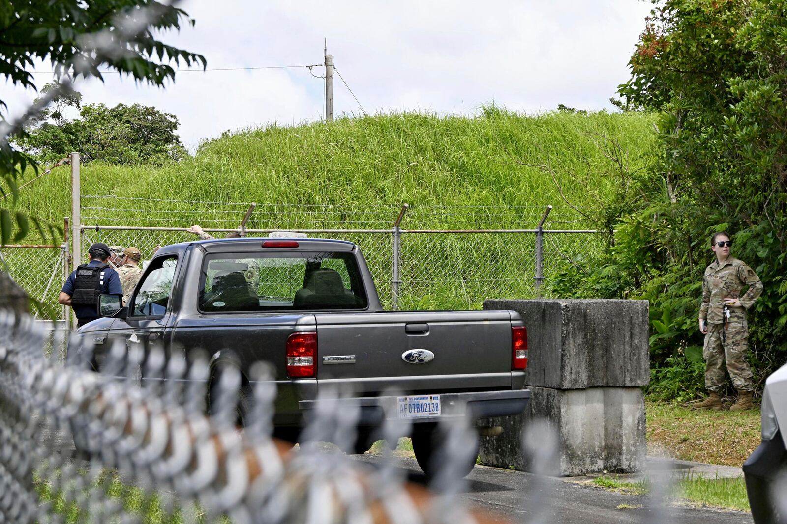 U.S. military persons gather near the site of an explosion at a storage site for unexploded ordnances at a U.S. military base in the town of Yomitanson, Okinawa prefecture, southern Japan Monday, June 9, 2025. (Kyodo News via AP)