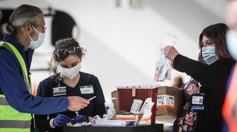 Premier Health workers prepare to vaccinate people from COVID-19 at an clinic held at the University of Dayton Arena Monday March 22, 2021.