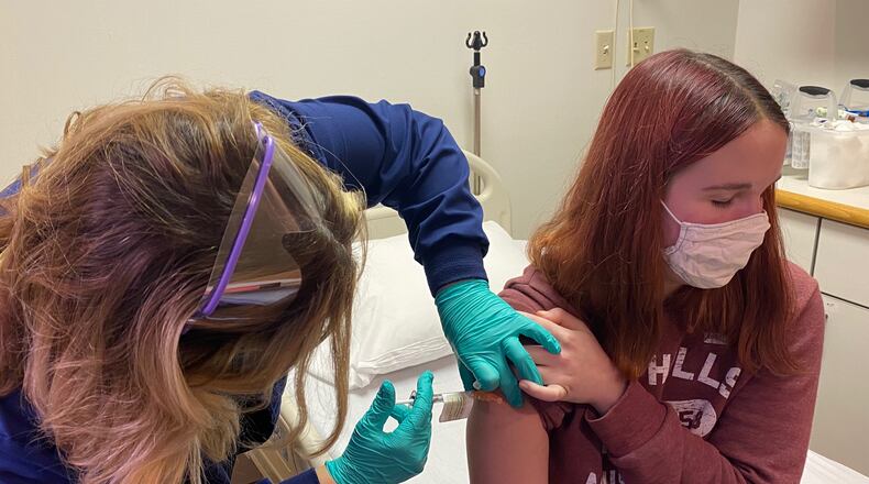 Katelyn Evans, 17, receives an injection at Cincinnati Children’s Hospital. She was the first adolescent enrolled in the COVID-19 vaccine clinical trial at Cincinnati Children’s.  PHOTO Credit Cincinnati Children’s