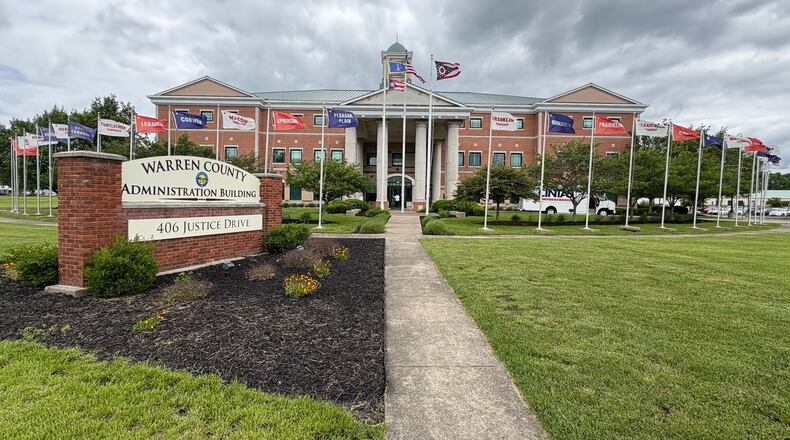The American flag, Ohio flag and Warren County flags fly in front of the Warren County Administration Building, 406 Justice Drive in Lebanon, which also has flags for the cities, villages and townships on the grounds. JEN BALDUF/STAFF