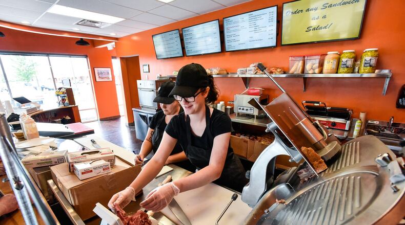 Assistant manager Alyssa Price, left, and Jillian Becker prepare sandwiches and Liberty Sandwich Factory Friday, July 6 in Liberty Township. The restaurant features homemade corned beef, hand-carved turkey sandwiches, a homemade Cuban sandwich with fresh pork and traditional staples such as ham-and-cheese sandwiches, turkey-and-cheese sandwiches and other deli meats and cheeses. The menu also will feature homemade baked beans, soups, chili, macaroni and cheese and more. NICK GRAHAM/STAFF