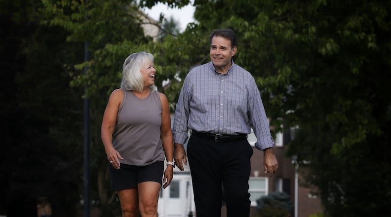 After a heart attack, Ray Bange walks with his wife, Peggy, as part of his rehabilitation in their neighborhood in Hamilton. NICK GRAHAM/STAFF