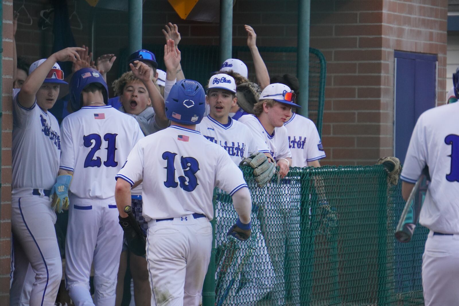 Hamilton's Kaleb Powers (13) is greeted by teammates after scoring a run against Talawanda on Saturday night at Stang Field.