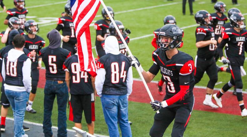 Franklin wide receiver Kyle Rickard (3) waves the U.S. flag as the team takes the field to play Edgewood at Atrium Stadium in Franklin Community Park, Friday, Sept. 1, 2017. GREG LYNCH / STAFF