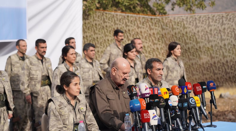 Kurdistan Workers' Party (PKK) fighters, who reportedly withdrew from Turkey with their weapons, stand to attention during a ceremony in the Qandil area of northern, Iraq, Sunday, Oct 26, 2025. (AP Photo/Rashid Yahya)