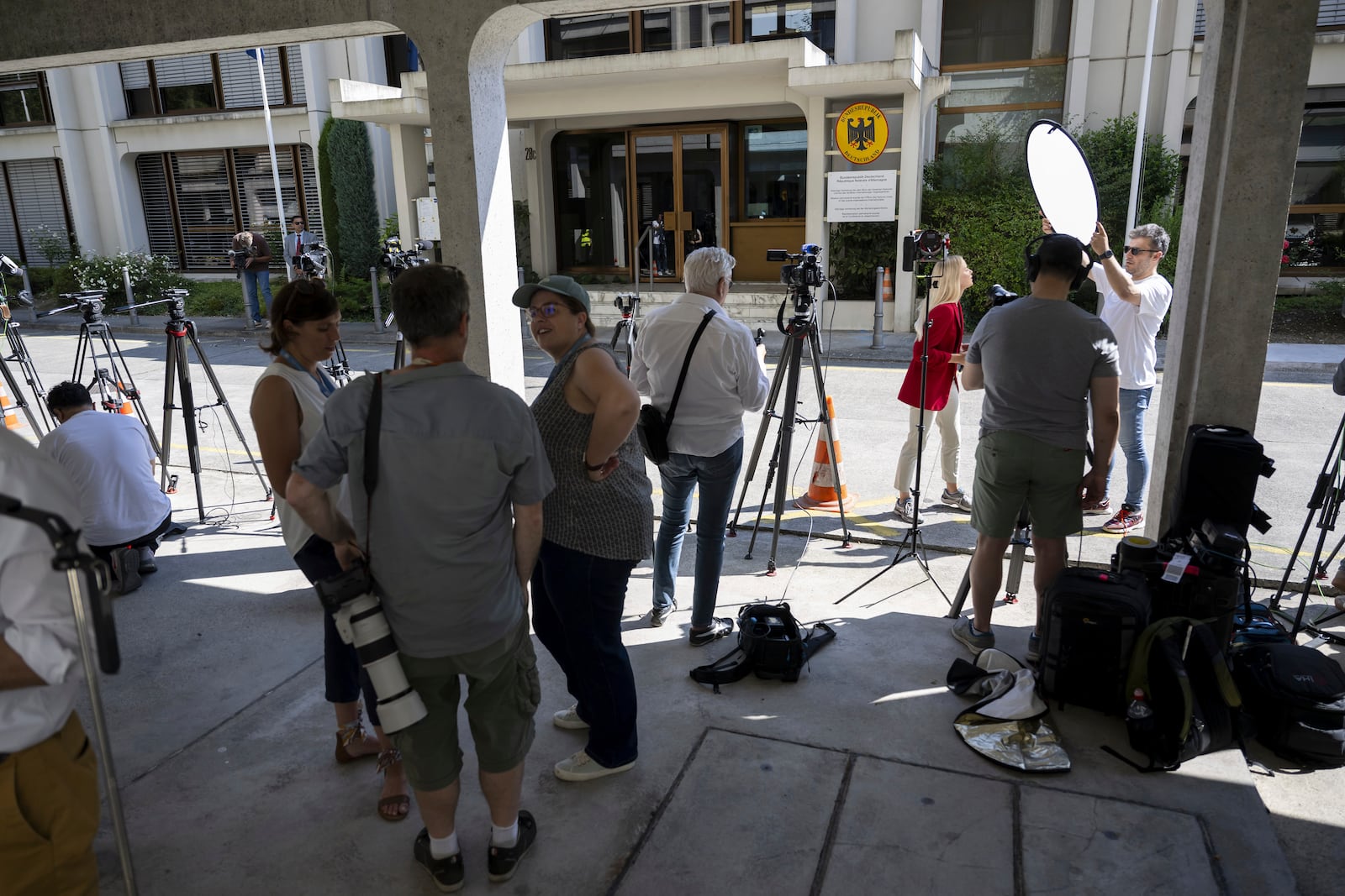 TV journalists work in front of the German Mission to the UN, ahead of a meeting for the Iran-EU nuclear meeting with the various foreign ministers of Germany, France, Great Britain and the EU to hold nuclear talks with their Iranian counterparts, in Geneva, Switzerland, Friday, June 20, 2025. (Martial Trezzini/Keystone via AP)
