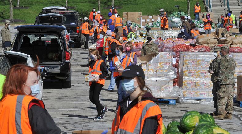 The Ohio National Guard and volunteers from The Foodbank in Dayton load food into vehicles at Wright State University's Nutter Center on Tuesday morning, April 21, 2020. MARSHALL GORBY/STAFF