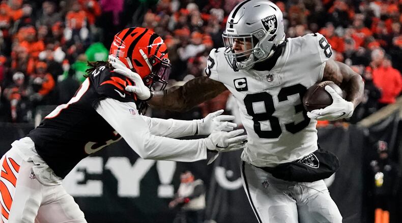 Las Vegas Raiders' Darren Waller (83) is tackled by Cincinnati Bengals' Tre Flowers (33) during the first half of an NFL wild-card playoff football game, Saturday, Jan. 15, 2022, in Cincinnati. (AP Photo/Jeff Dean)