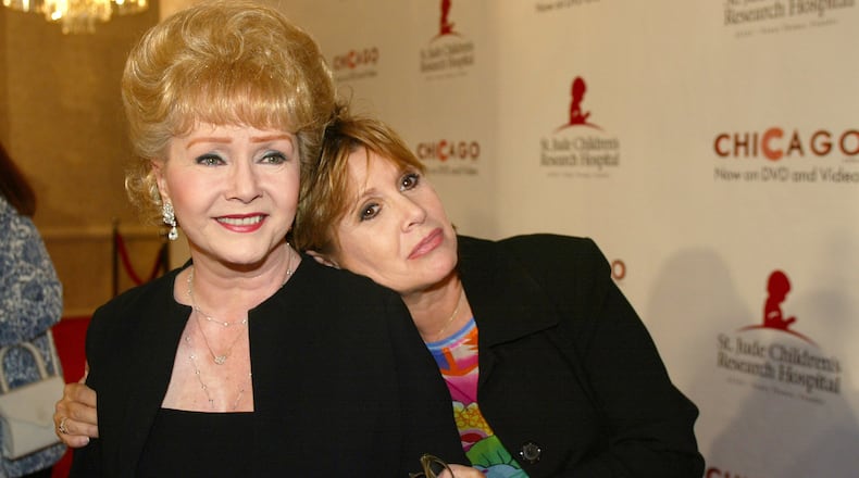 FILE - In this Tuesday, Aug. 19, 2003 file photo, Debbie Reynolds and Carrie Fisher arrive at the "Runway for Life" Celebrity Fashion Show Benefitting St. Jude's Children's Research Hospital and celebrating the DVD relese of Chicago in Beverly Hills, Calif. On Tuesday, Dec. 27, 2016, a publicist said Fisher has died at the age of 60. (AP Photo/Jill Connelly, File)