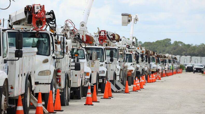 A line of electrical line trucks is pictured at Duke Energy's staging location in Sumterville, Fla., on Tuesday, Aug. 29, 2023. Duke Energy is staging thousands of workers and trucks in preparation for the arrival of Hurricane Idalia. (Stephen M. Dowell /Orlando Sentinel via AP)