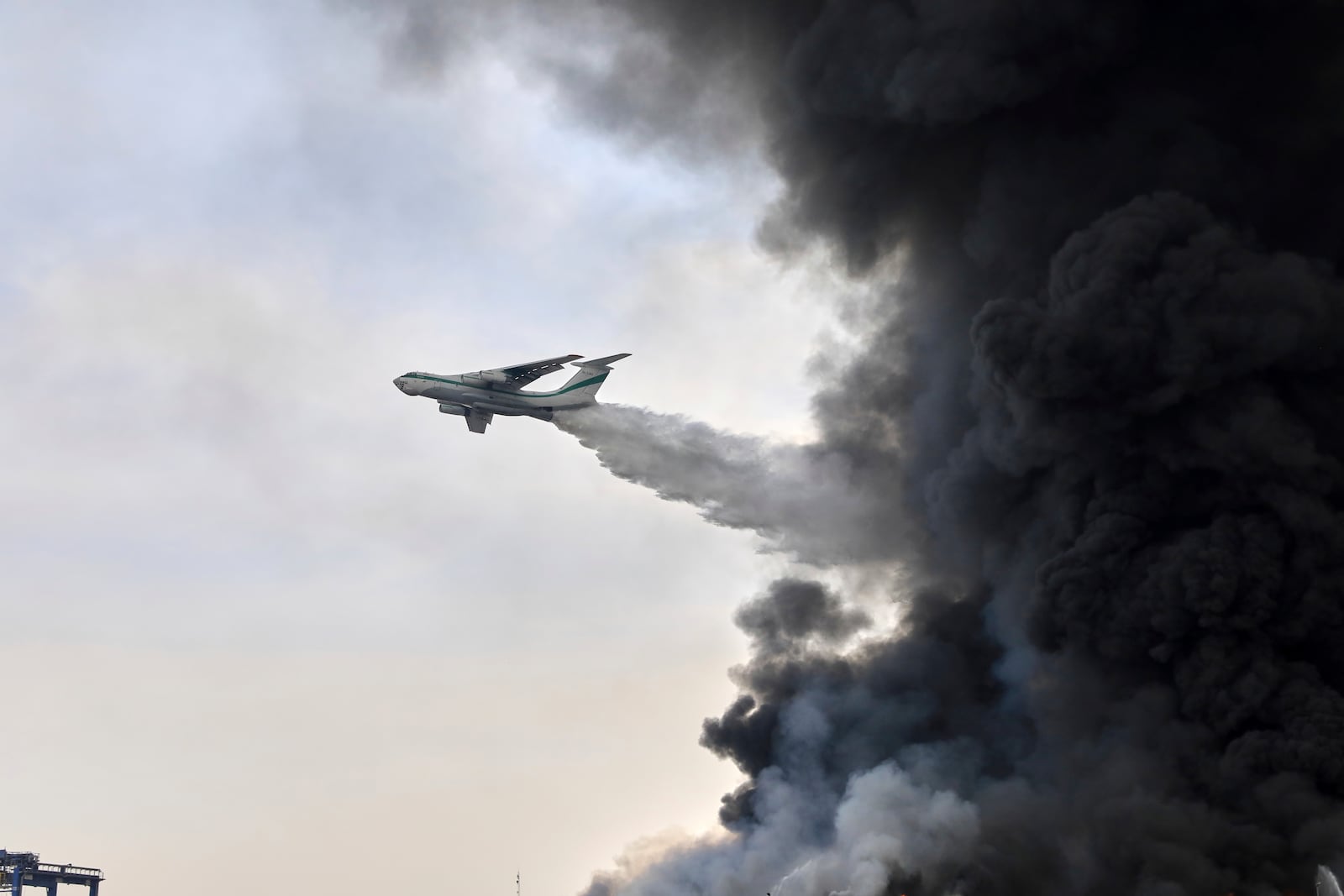 A revolutionary Guard firefighting airtanker drops water on the fire, Sunday, April 27, 2025, after a massive explosion and fire rocked a port near the southern port city of Bandar Abbas, Iran, on Saturday. (AP Photo/Mahdi Nori/Fars News agency)
