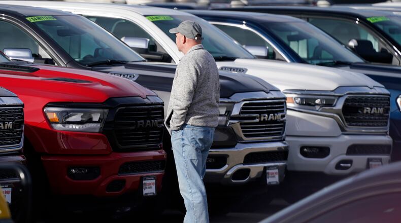 A prospective buyer surveys a long row of unsold 2020 pickup trucks at a Ram dealership, Sunday, Dec. 27, 2020, in Littleton, Colo. (AP Photo/David Zalubowski)