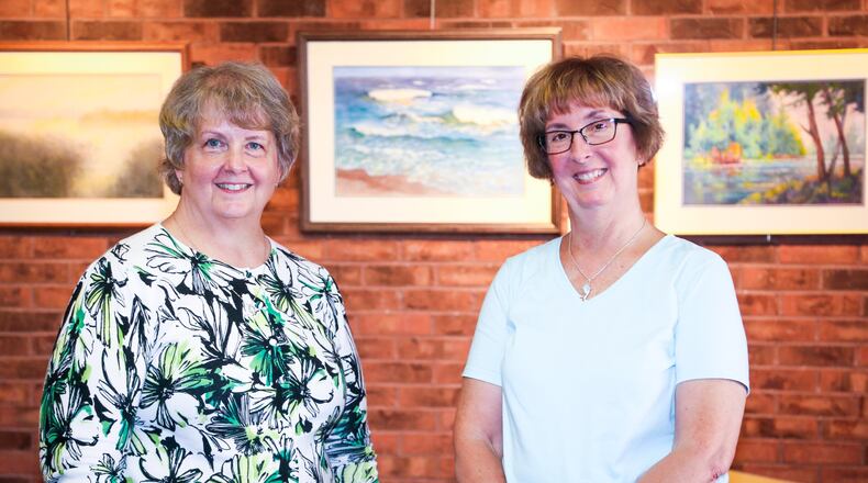 Bev Stolzenberger and Dianne Misins, daughters of Pat Brewer, pose with paintings their mother did that are part of a new exhibit of her work at the Middletown Arts Center.