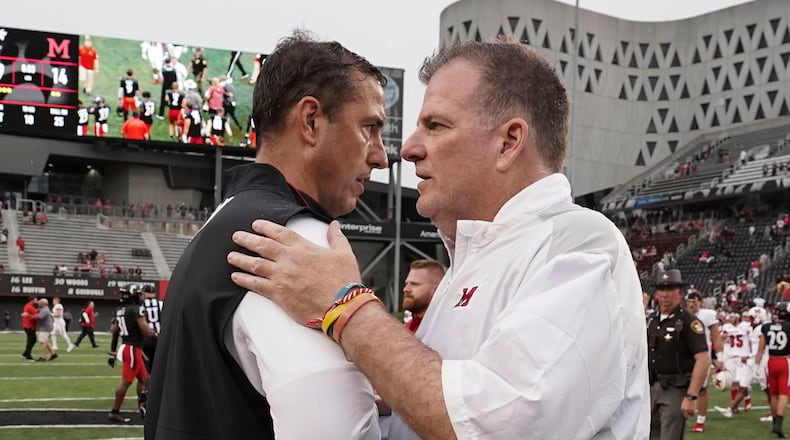 Cincinnati head coach Luke Fickell, left, shakes hands with Miami (Ohio) head coach Chuck Martin, right, at the completion of an NCAA college football game Saturday, Sept. 4, 2021, in Cincinnati. (AP Photo/Jeff Dean)