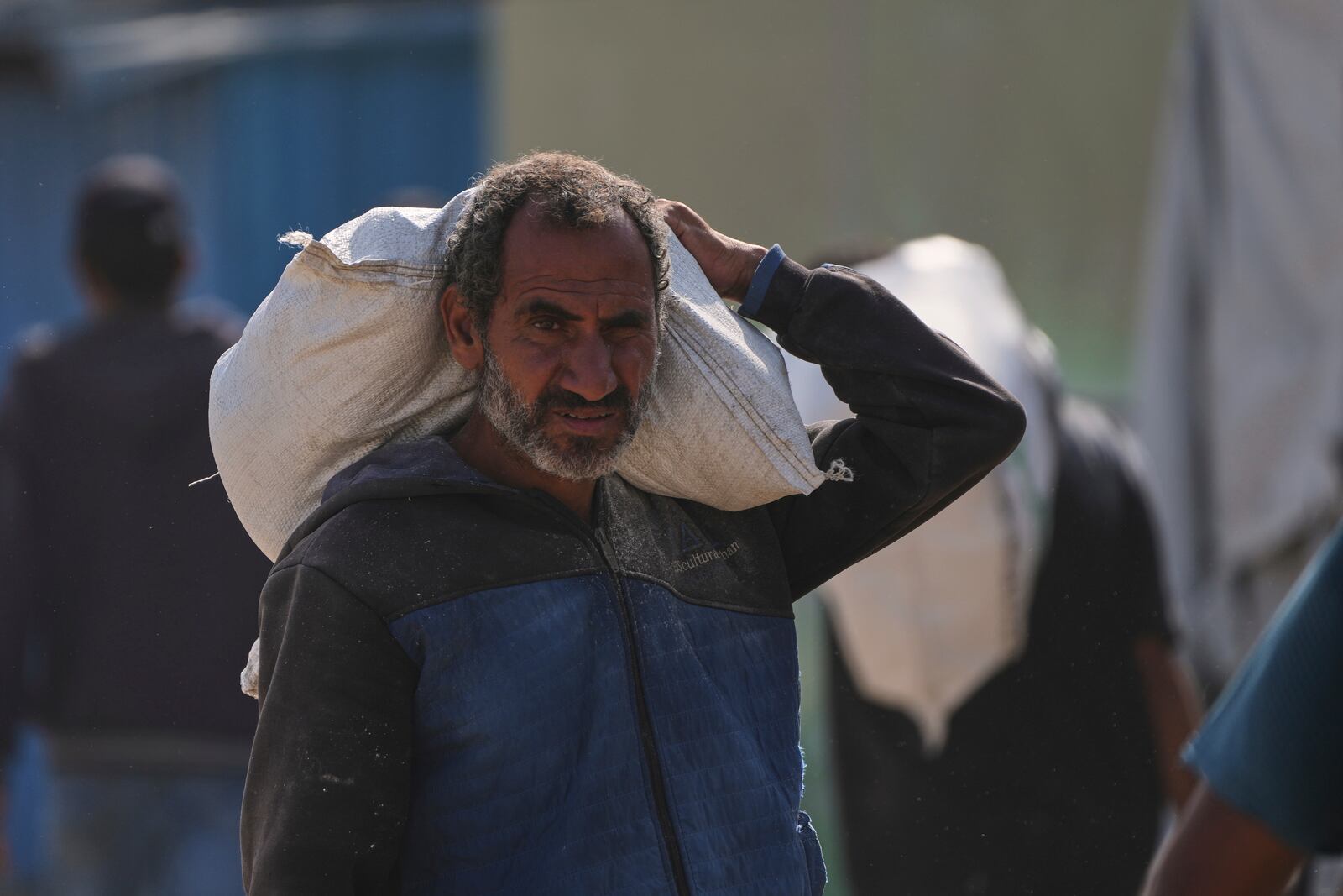 A Palestinian man carries a bag of food after receiving aid from the Gaza Humanitarian Foundation, a U.S.-backed organization approved by Israel, in Khan Younis, southern Gaza Strip, Sunday, June 1, 2025. (AP Photo/Abdel Kareem Hana)