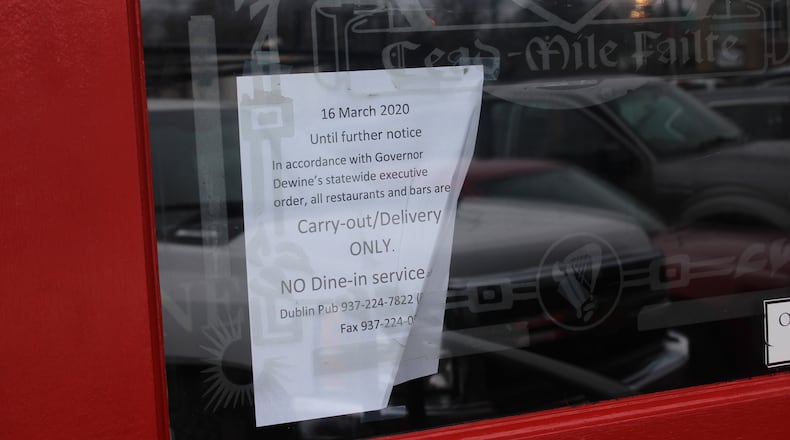Business owners pushed through or closed shop in the Oregon District in Dayton after Gov. Mike DeWine issued ordered that all restaurants must be carry-out or delivery only. AMELIA ROBINSON/STAFF