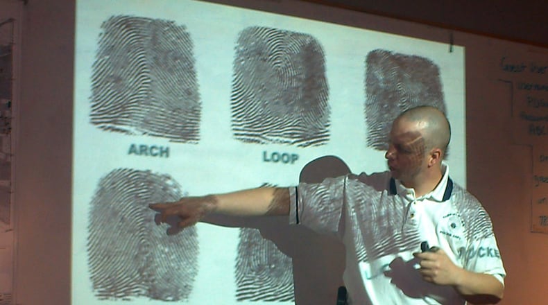 Members of the Fairfield Twp. Citizens Police Academy learn about crime scene investigations. Pictured during a class in 2009, then-Sgt. Doug Lanier talks about fingerprints. FILE