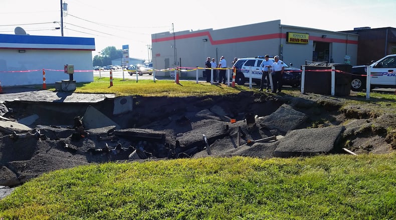 Officials continued to investigate the scene Tuesday where a fuel-tank explosion forced evacuations and left a crater in the ground during Monday evening’s storms. GREG LYNCH/ STAFF