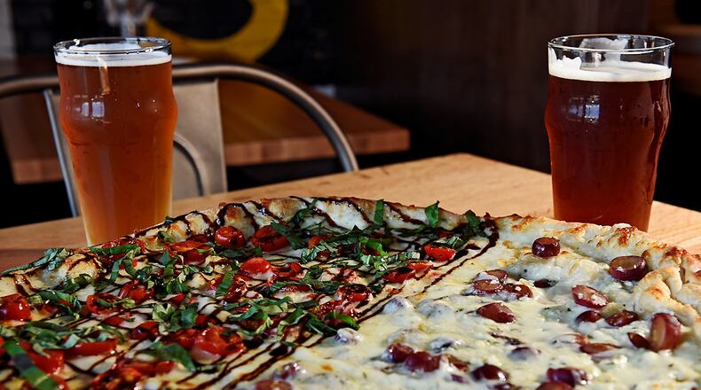 Pies & Pints will be one of the restaurants that will occupy the new Liberty Center development when it opens later this year in Liberty Twp. The restaurant recently opened a location on High Street in Columbus. This pizza is half Mozzarella Caprese with fresh mozzarella, tomatoes, basil and a balsamic reduction and half Grape & Gorgonzola with red grapes, gorgonzola and fresh rosemary. NICK GRAHAM/STAFF