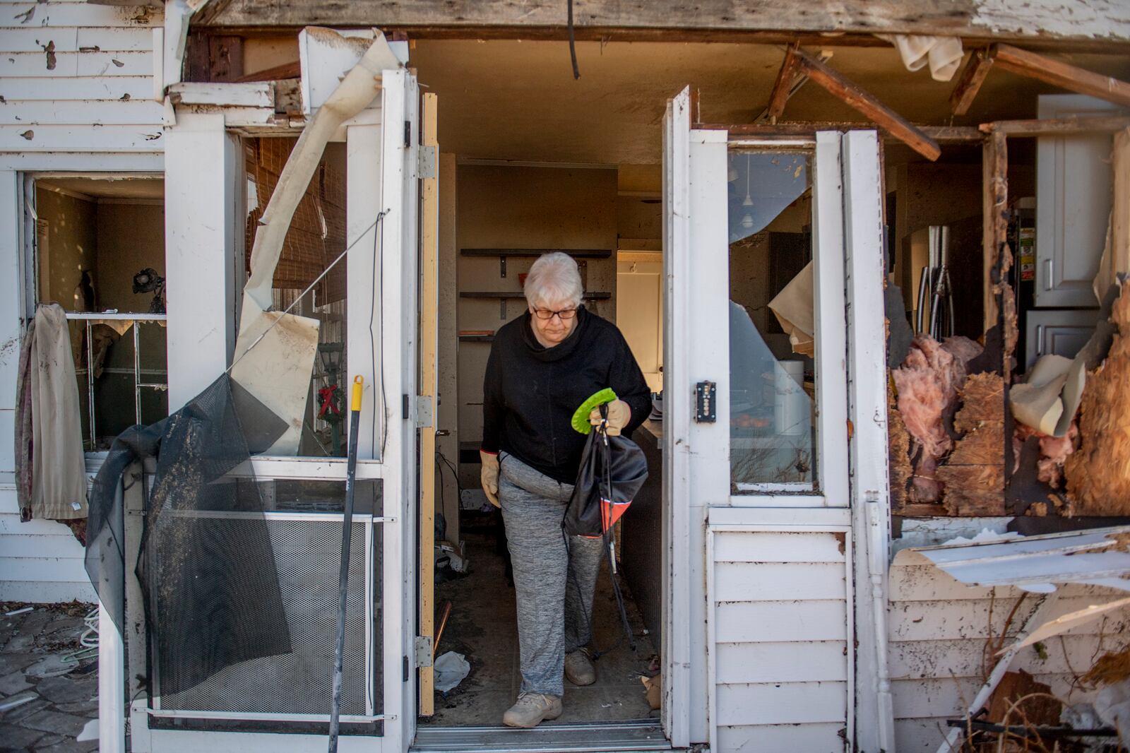 Martha Thomas salvages items from her damaged home in Mayfield, Ky. on Monday, Dec. 13, 2021, after a tornado swept across the region days earlier. Determining how many people died in the tornadoes that ravaged the central U.S. on Friday has been a challenging task so far, with estimates fluctuating as search teams continue to spread out amid vast fields of rubble in an effort to rescue the living and account for the dead. (Johnny Milano/The New York Times)