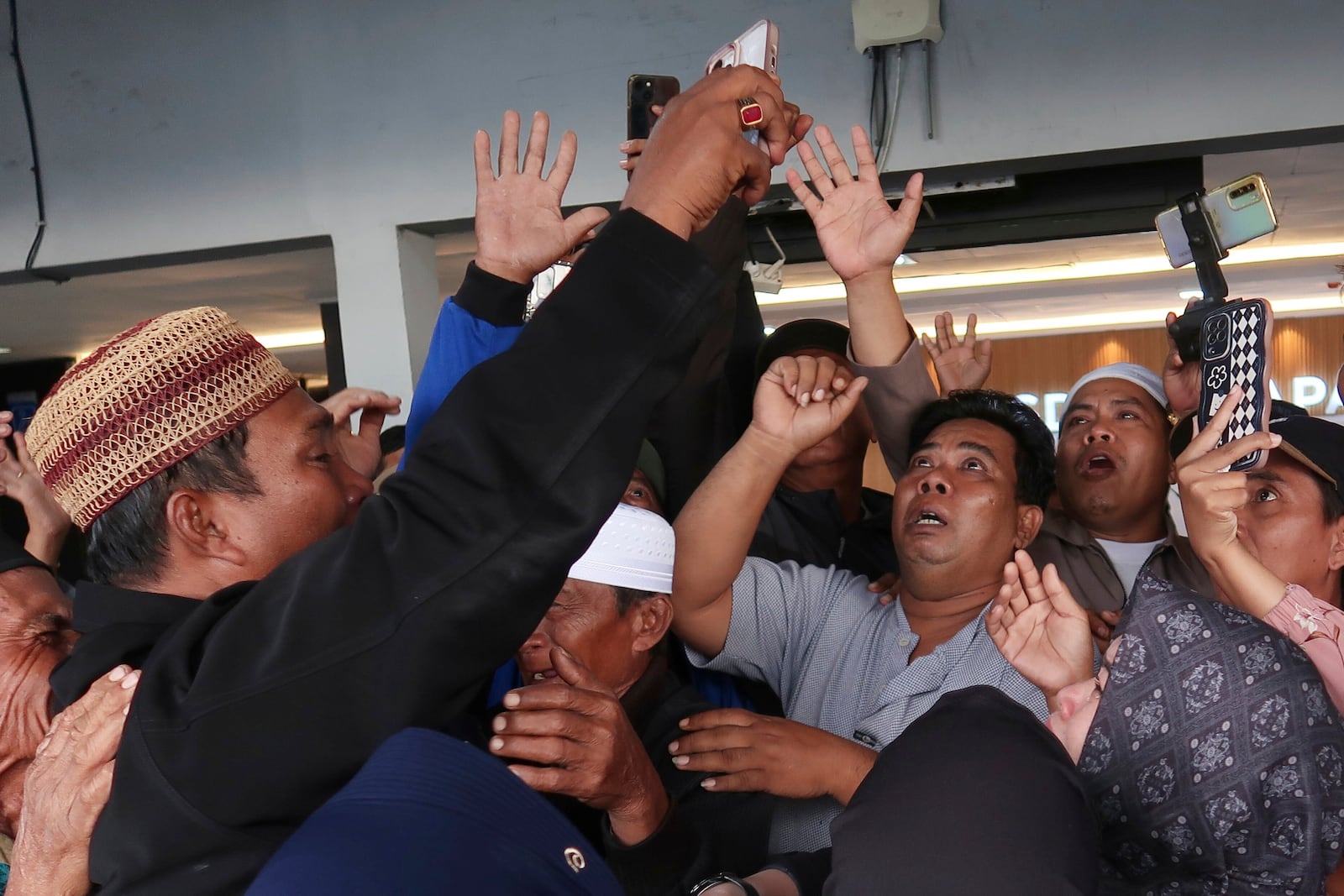 Relatives react as they have a video call with a survivor from a ferry that sank near the resort island of Bali, at Ketapang Port in Bayuwangi, East Java, Indonesia, Thursday, July 3, 2025. (AP Photo/Andur)
