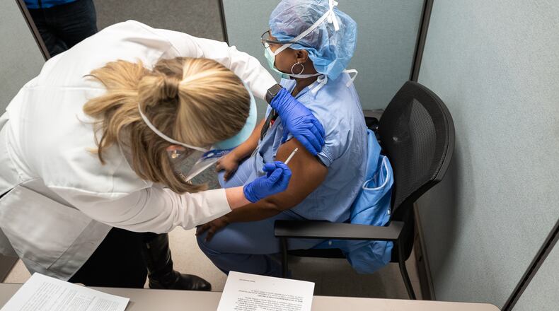Pictured is a healthcare worker at UC Health in Cincinnati receiving on Monday, Dec. 14, 2020, the new novel coronavirus vaccine developed by Pfizer. Ohio received its first deliveries of the COVID-19 vaccine on Monday and UC Health was one of the first in Southwest Ohio to receive it. PROVIDED/UC HEALTH