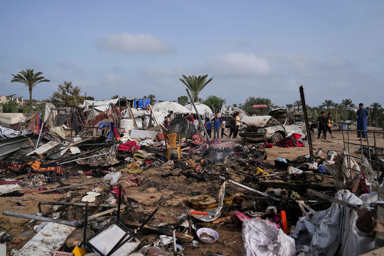 Palestinians inspect the site destroyed by Israeli airstrikes in Khan Younis, Gaza Strip, Sunday, May 18, 2025. (AP Photo/Abdel Kareem Hana)
