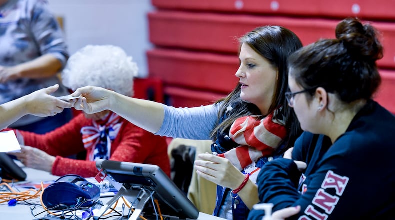 Poll workers across Butler County are needed for the May 8 primary election. Pictured is poll worker Terrah Roberts hands a voter back her driver's license on Tuesday, Nov. 3, 2015, inside the Auxiliary Gym building at Madison Local Schools in Madison Twp. NICK GRAHAM/STAFF