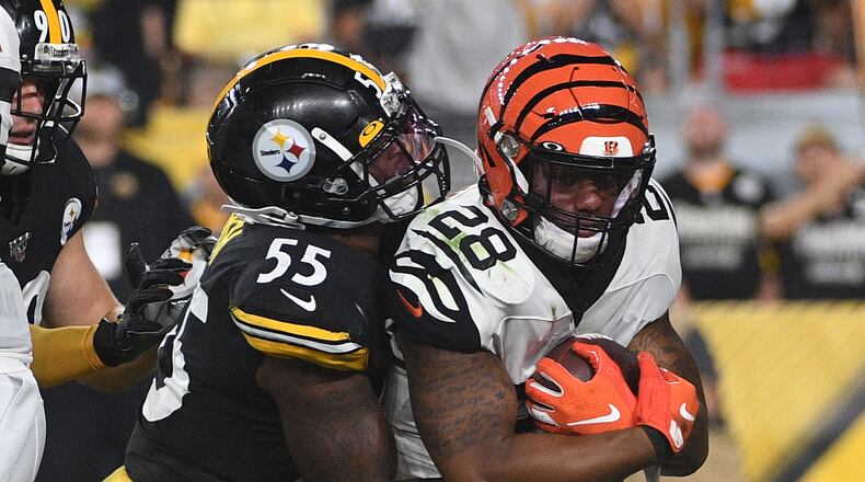 PITTSBURGH, PA - SEPTEMBER 30: Joe Mixon #28 of the Cincinnati Bengals is wrapped up for a tackle by Devin Bush #55 of the Pittsburgh Steelers in the first quarter during the game at Heinz Field on September 30, 2019 in Pittsburgh, Pennsylvania. (Photo by Justin Berl/Getty Images)