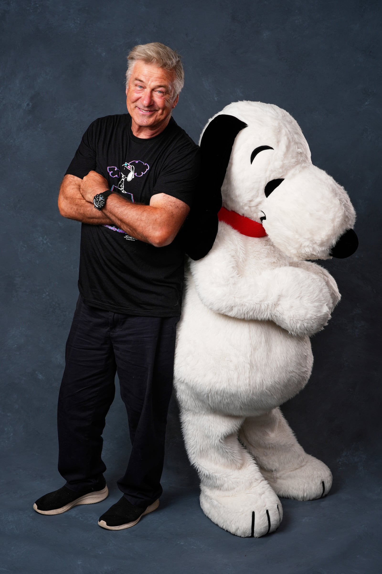 Alec Baldwin, left, and a person dressed as the character Snoopy from "Peanuts" poses for a portrait to promote the 75th anniversary of "Peanuts" during Comic-Con International on Thursday, July 24, 2025, in San Diego. (AP Photo/Chris Pizzello)