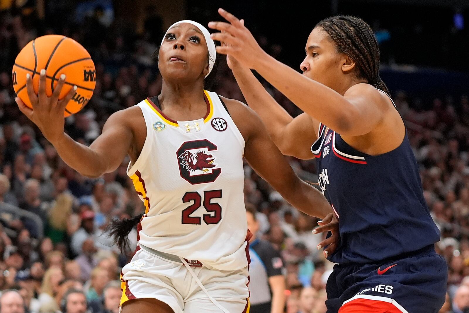 South Carolina guard Raven Johnson (25) drives to the basket against UConn forward Sarah Strong (21) during the first half of the national championship game at the Final Four of the women's NCAA college basketball tournament, Sunday, April 6, 2025, in Tampa, Fla. (AP Photo/John Raoux)